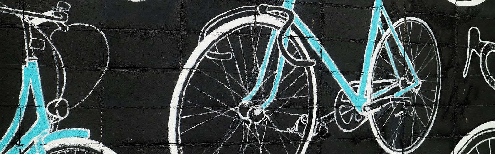 A close up shot of a Graffiti in Bangkok showing bicycles in neon blue and white colours.