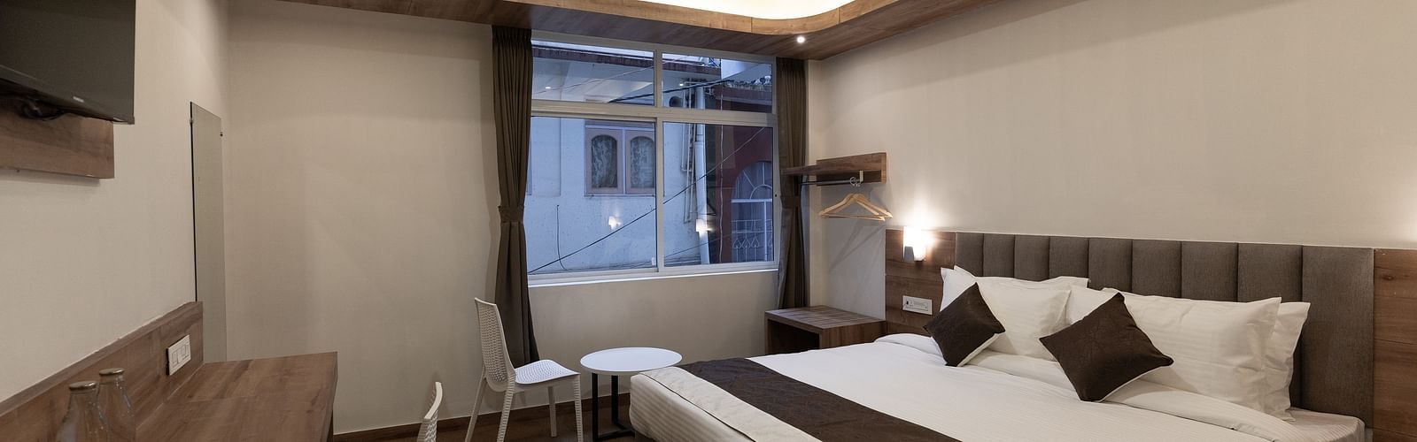 image of the Standard room with a king size bed and a window in the corner at The Soma Hotel by Avianna Group, Darjeeling