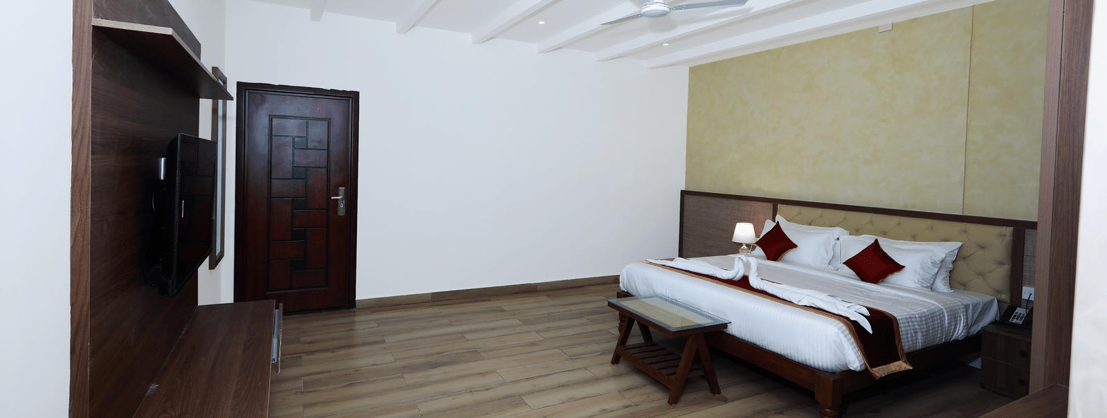 A wide-angle shot of the Nature Luxury Room featuring a well-kept double bed at WOW Naturefull Resorts, Yercaud.
