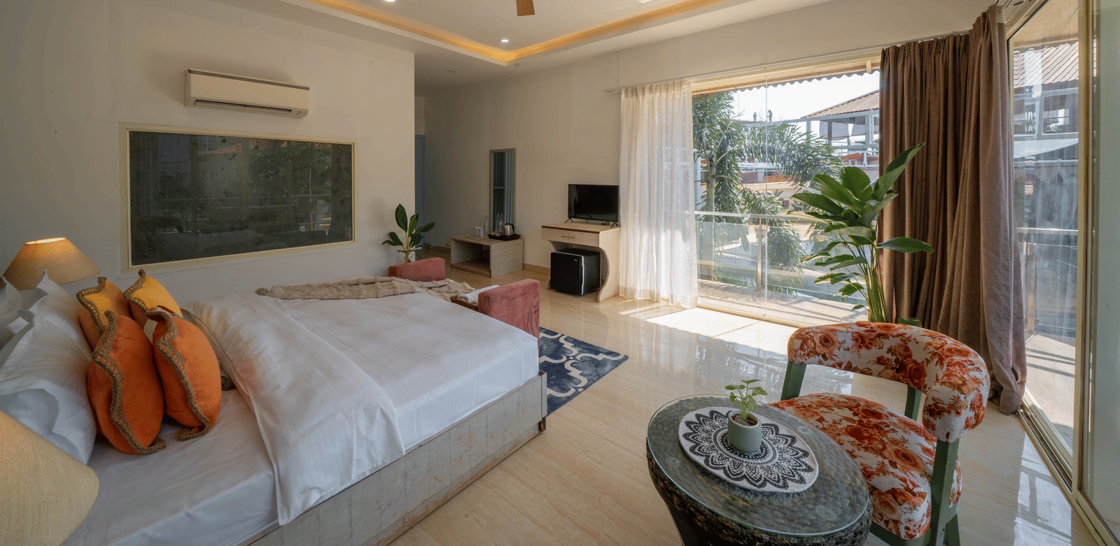 A room featuring a king size bed with a bedside lamp casting warm light, a wall-mounted television, and a balcony with a pool view - Perfectstayz Koko Maya