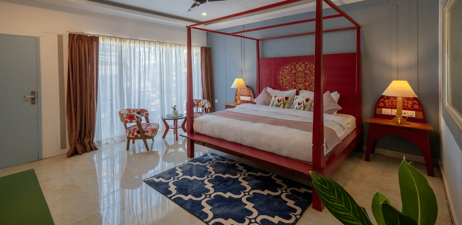 A room with warm ambient lighting, a 4-poster bed, a cosy seating area, and a potted plant - Perfectstayz Koko Maya