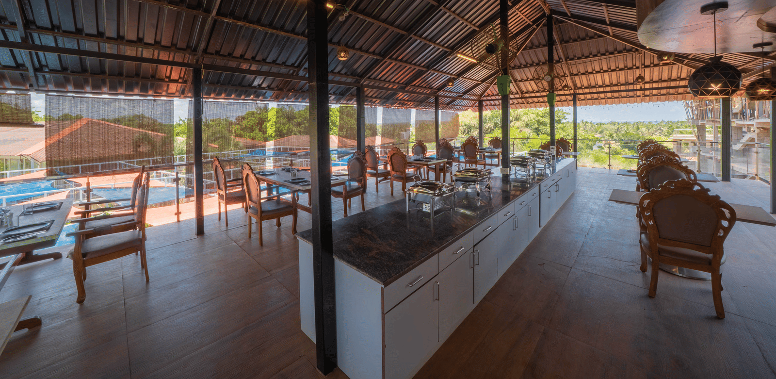 Our restaurant offering 4-person seating areas, a central buffet counter, and a view of Morjim Beach - Perfectstayz Koko Maya