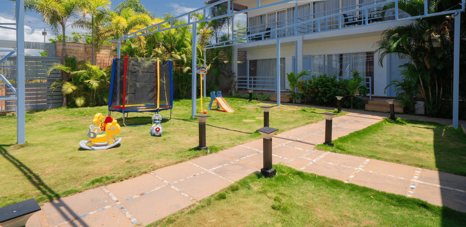 The kids’ play area featuring a mini trampoline, a small slide, and horse-shaped rocking chairs - Perfectstayz Koko Maya