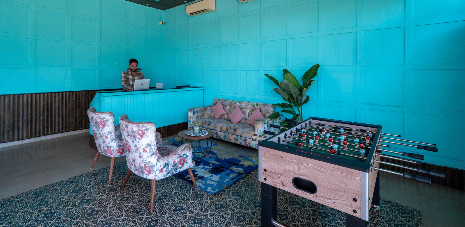 A foosball table at the reception area, accompanied by a seating corner and the reception desk nearby - Perfectstayz Koko Maya