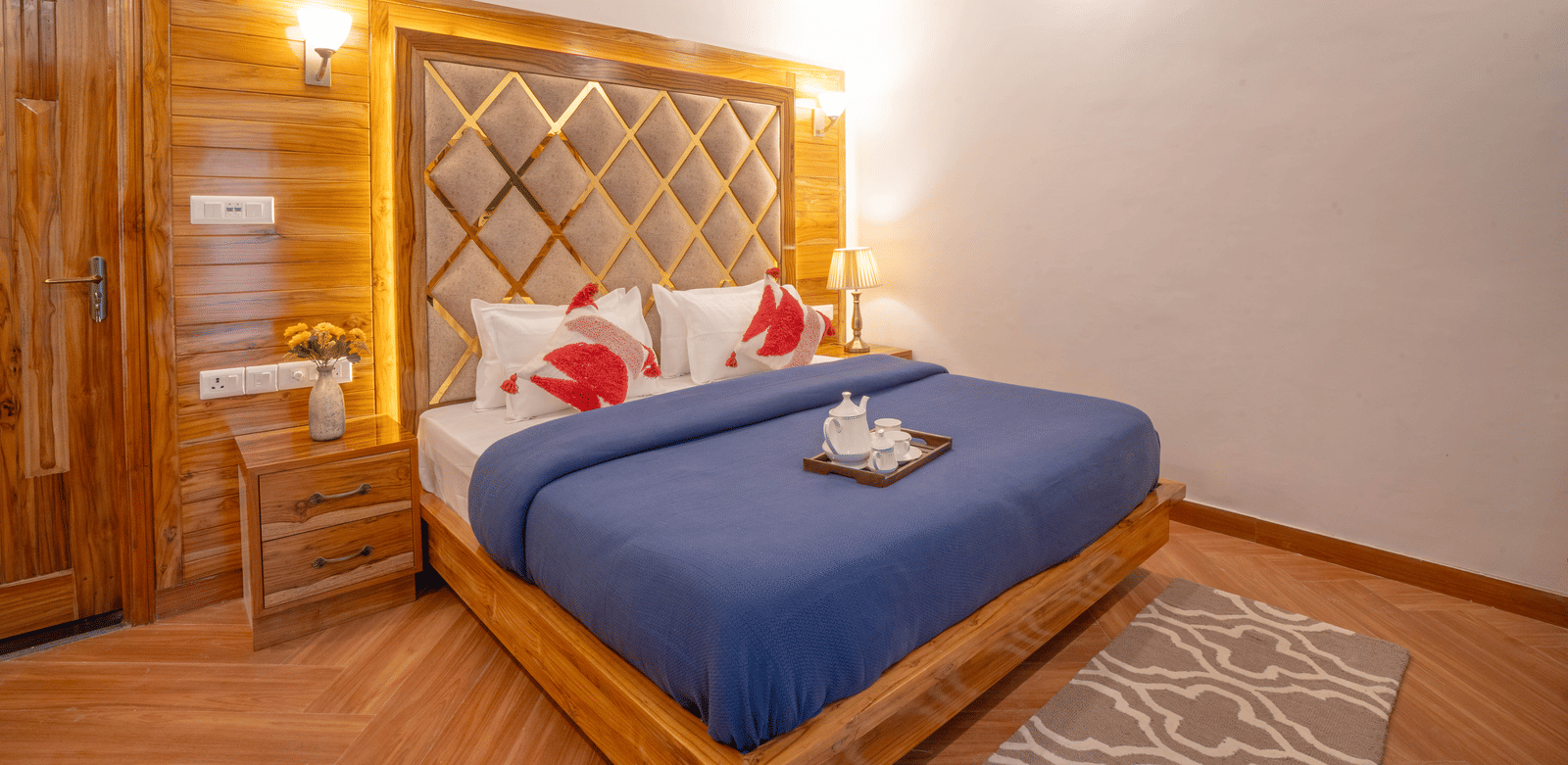 A bedroom featuring a king size bed, a bedside table, a tray with cups and a kettle at Perfectstayz Value Paradise, Mussoorie.