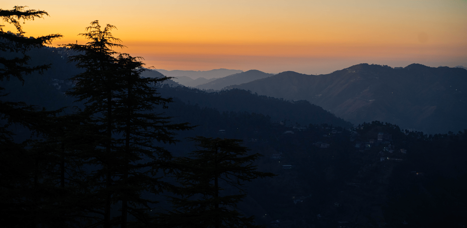 A sunset view over distant hills and trees near Perfectstayz Value Shimla (Namah Retreat).