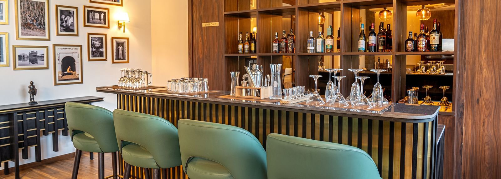 Stylish bar with gallery wall and pendant lights at Nivasana Manali.