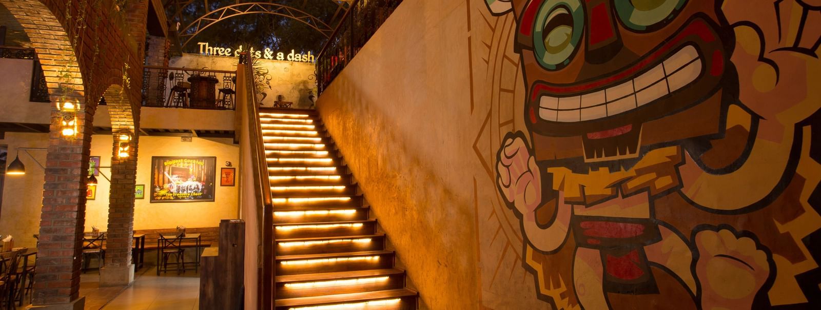 a staircase leading upstairs with graffiti on the wall beside the staircase - Hotel Fountain Tree By TGI - JP Nagar, Bangalore