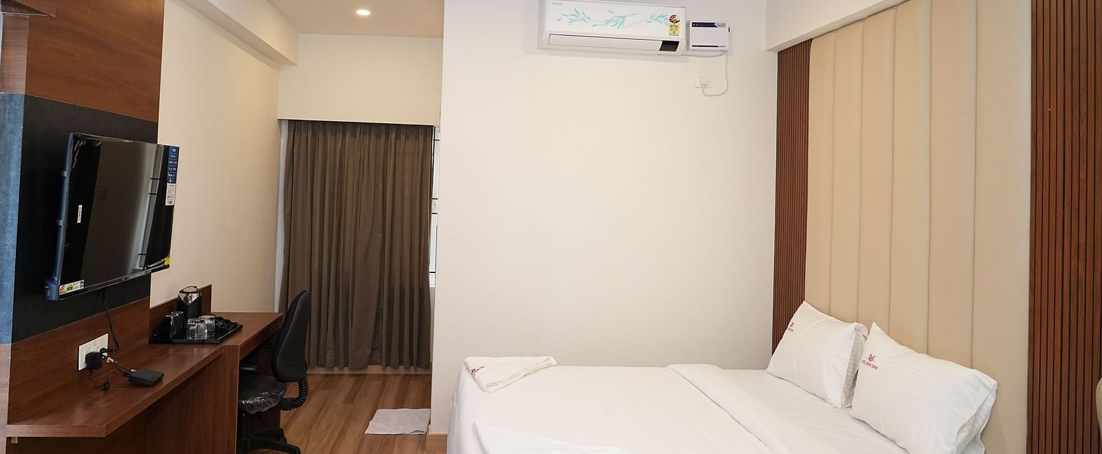 side view of the premium executive room featuring a neatly kept double bed along with wall mounted television - Hotel Grand Sigma