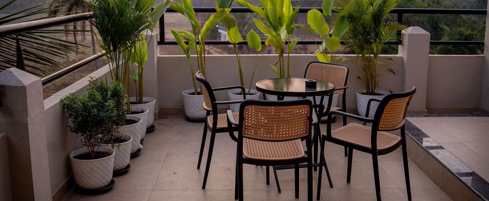 Balcony dining setup surrounded by potted plants and scenic views at Kssemya.