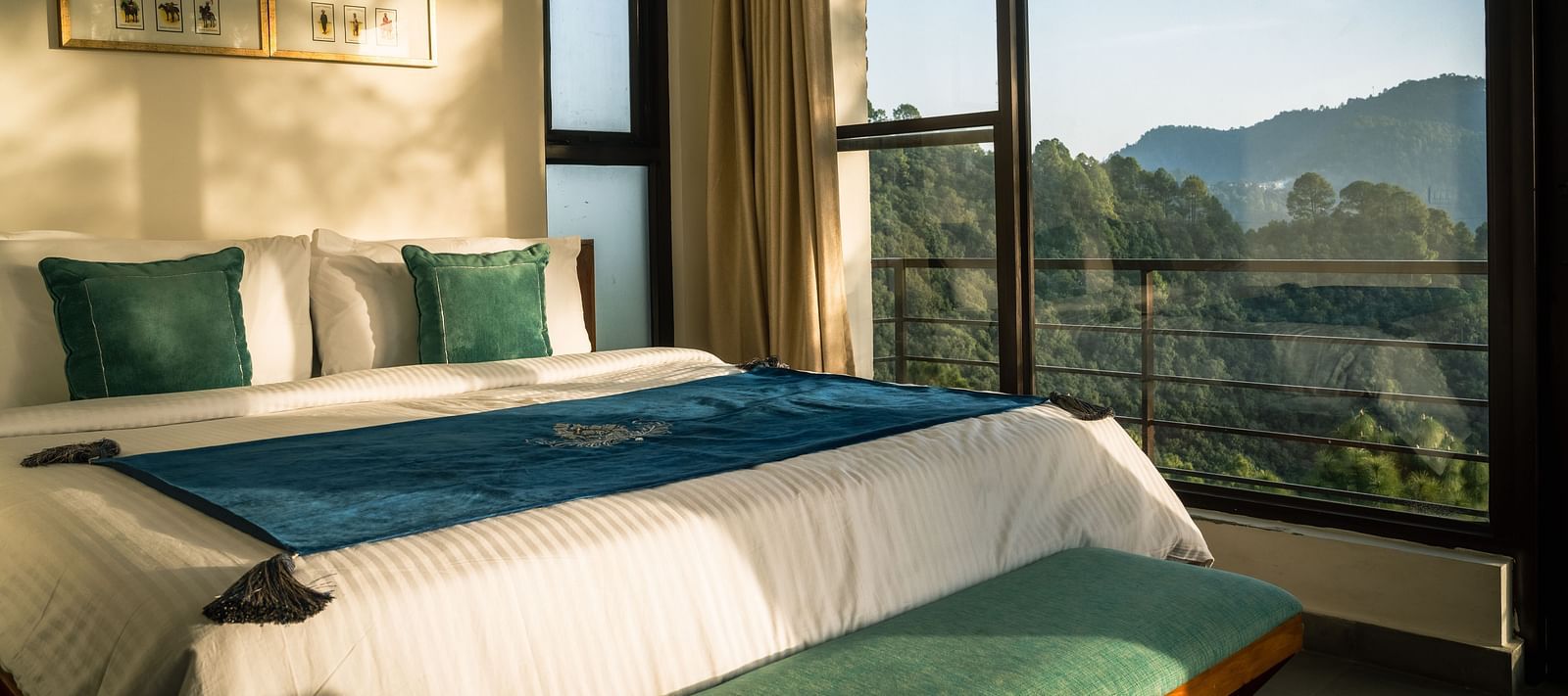 A bedroom with a balcony offering a mountain view and sunlight streaming in at BluSalzz Escapade Resort, Lansdowne