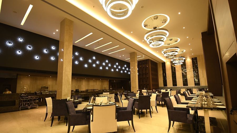 A dining area with warm lighting, where tables are set and chairs are arranged for guests to enjoy their meal