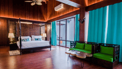 an overview of the Beach Mansion with a king bed in the centre and a tv and sofa on either side - Symphony Summer Sand Beach Resort And Spa, Neil Island