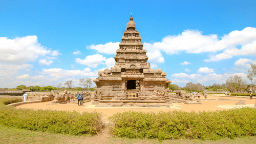 Mahabalipuram temple surrounded by green grass and blue sky in the background