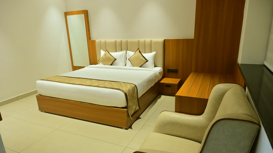 Suite of Bhavanis Vista By Icon featuring a bed, a headboard, and an armchair.