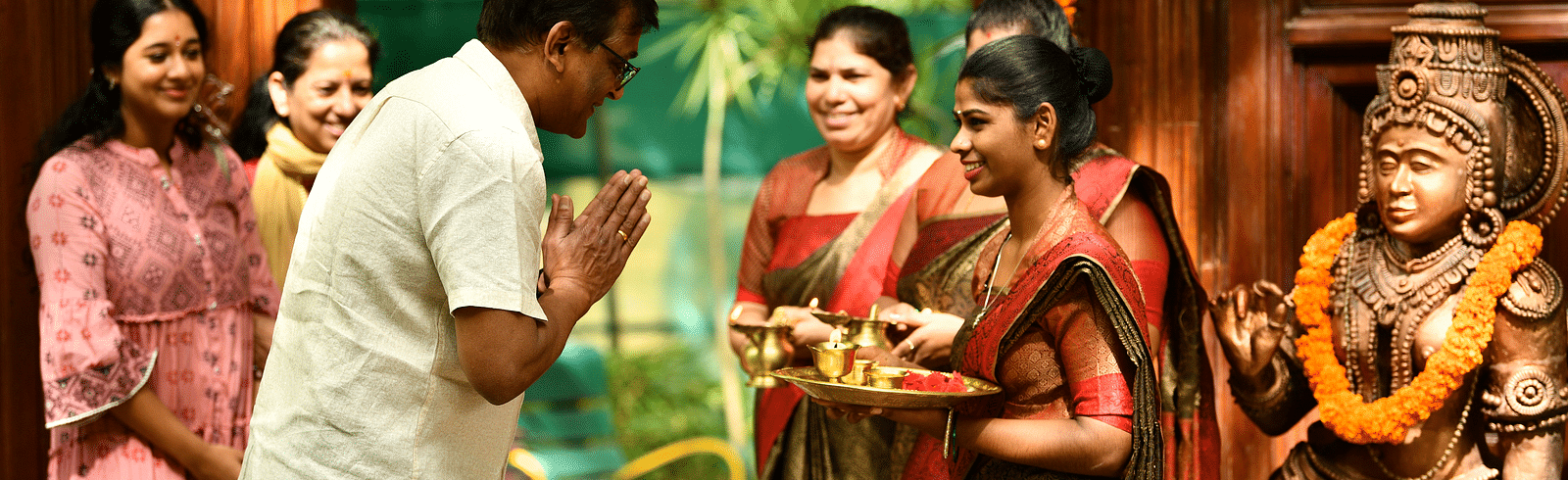 staff welcoming guests with tilak at Hoysala Village Resort, Hassan