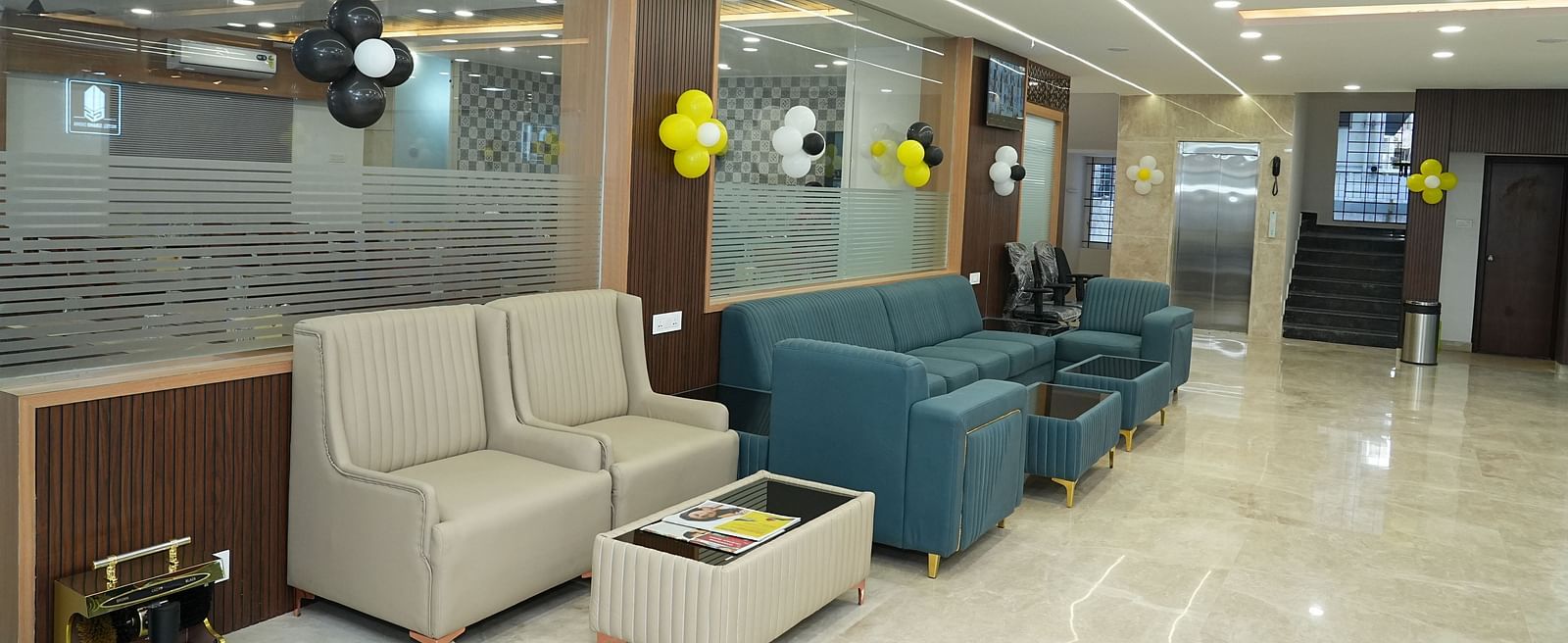the seating area of the lobby with centre tables in front of the couch with magazines kept over it - Hotel Grand Sigma