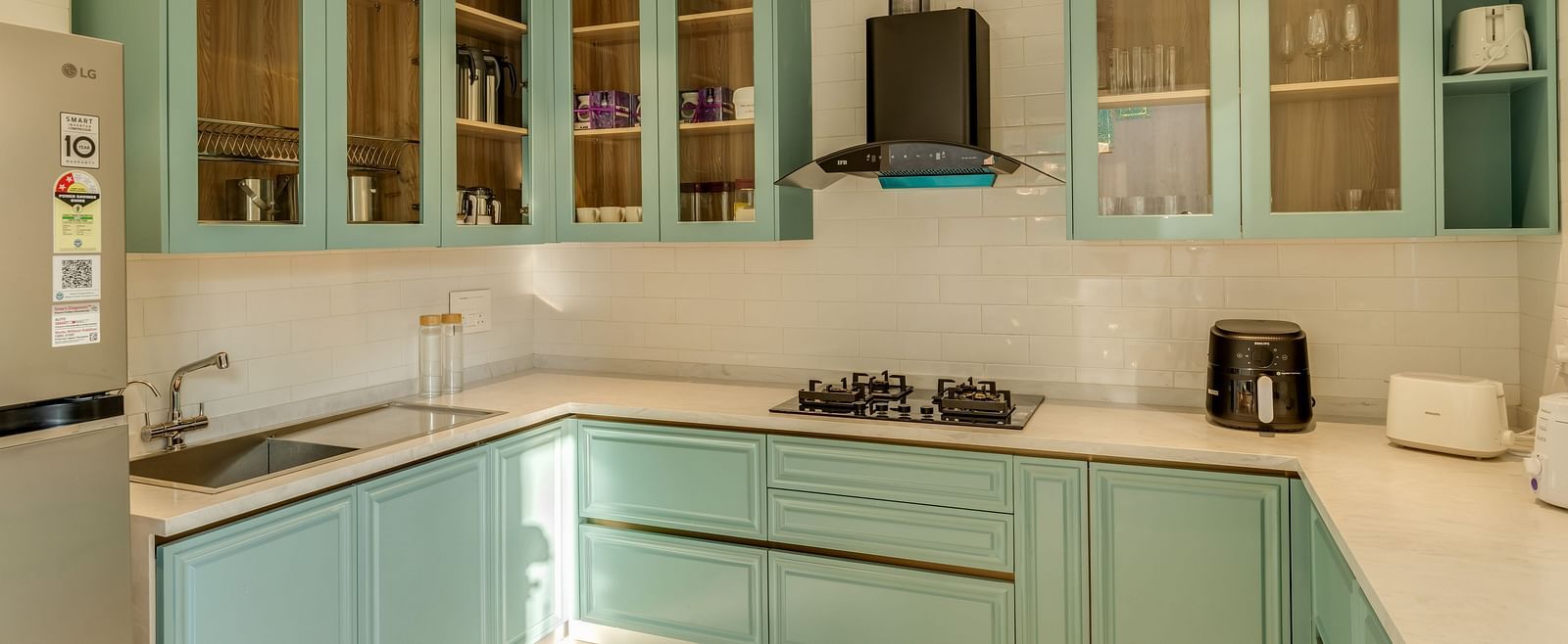 A sleek kitchen with pastel-coloured cabinets, integrated appliances, and a bright, airy ambience.
