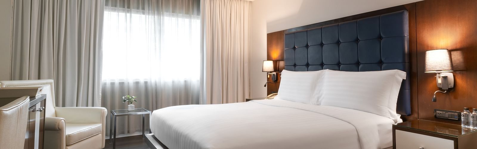 An overview of a double bed with lamps on the side inside one of the rooms - Night Hotel Bangkok