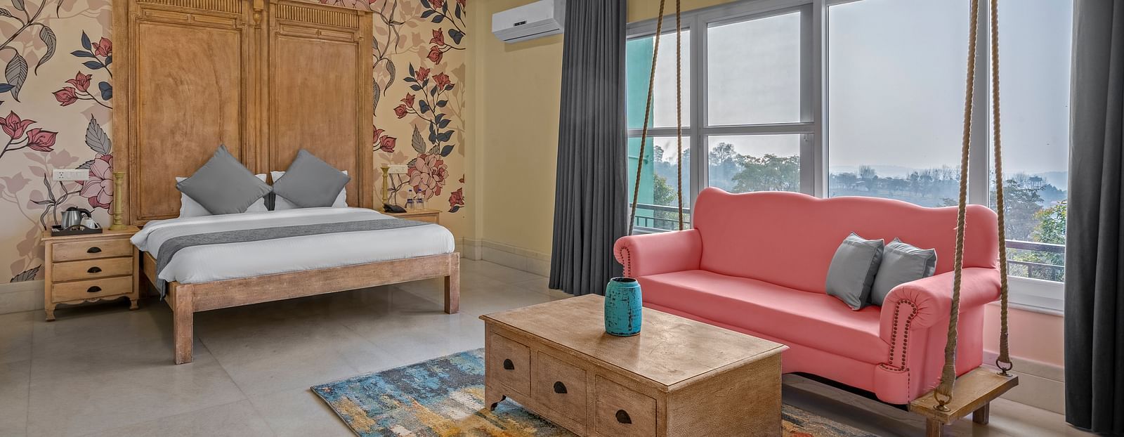 An image featuring a spacious bedroom with a king-size bed, a sofa, and a large window with a view - atman, dharamshala