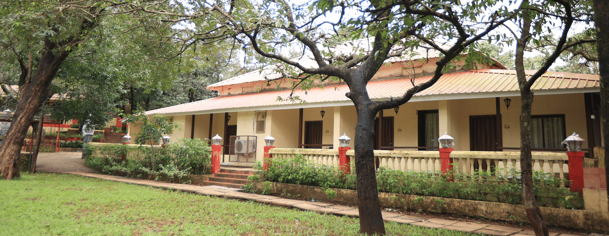 Image featuring a wide building Exterior with trees around -  Adamo the Village