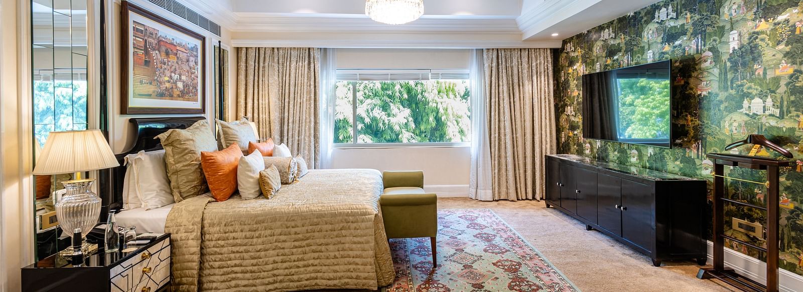 Presidential Suite at The Claridges New Delhi, featuring a king-sized bed with a bedside lamp and a wall-mounted TV