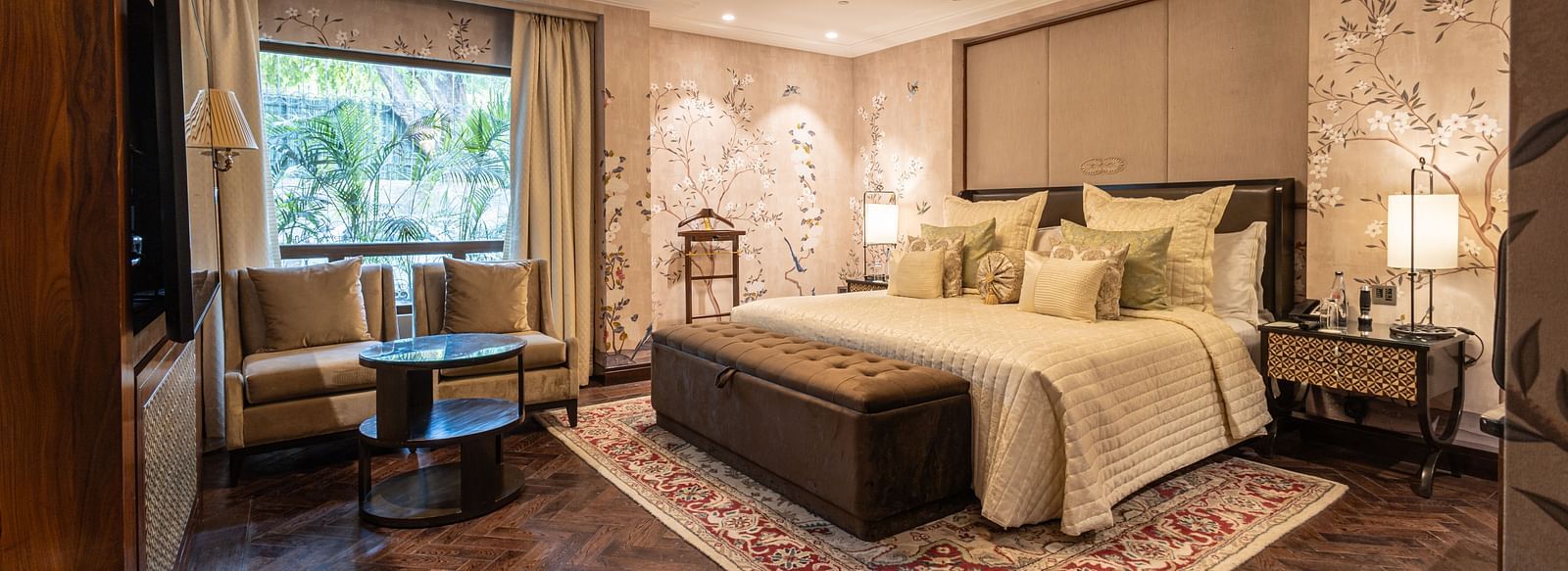 image of the bedroom of the cabana room featuring a modern interior with grey themed colour tone - Image of the Cabana Room featuring two single-seater couches and a wall-mounted television - The Claridges New Delhi