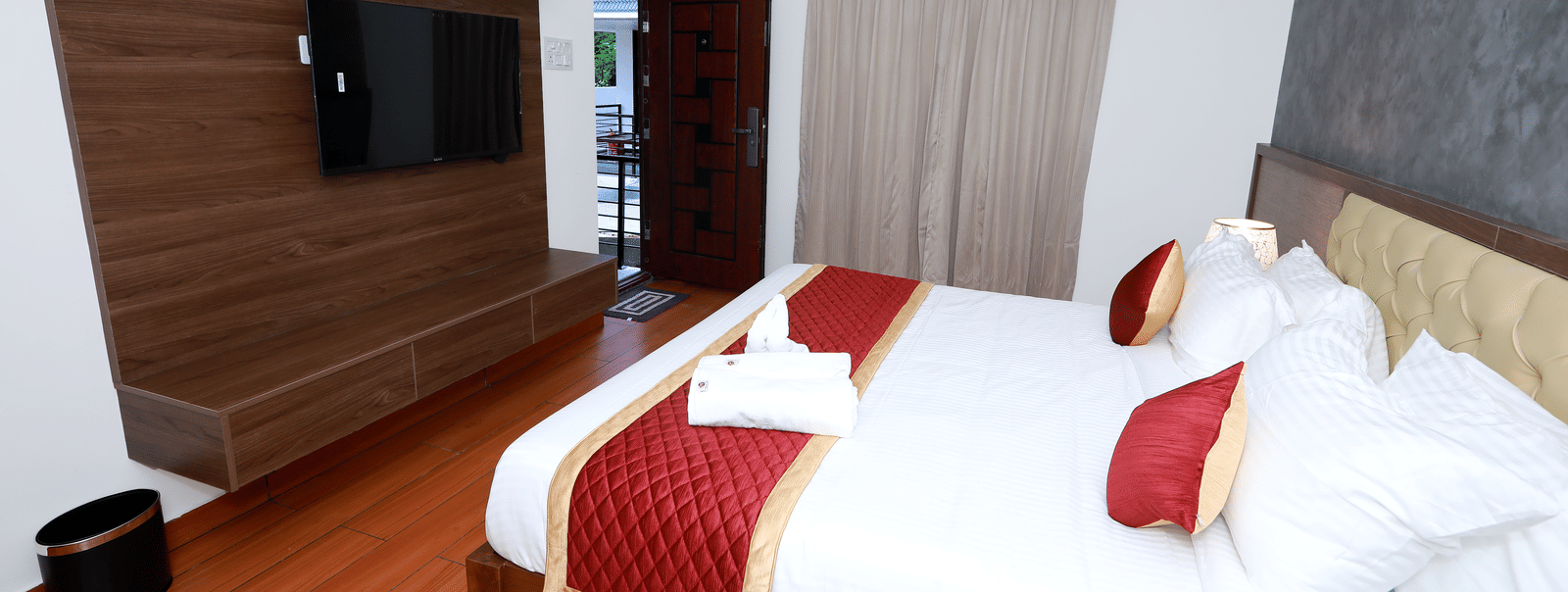Corner-view shot of the Standard Room with a double bed facing towards a wall-mounted television at WOW Naturefull Resorts, Yercaud.