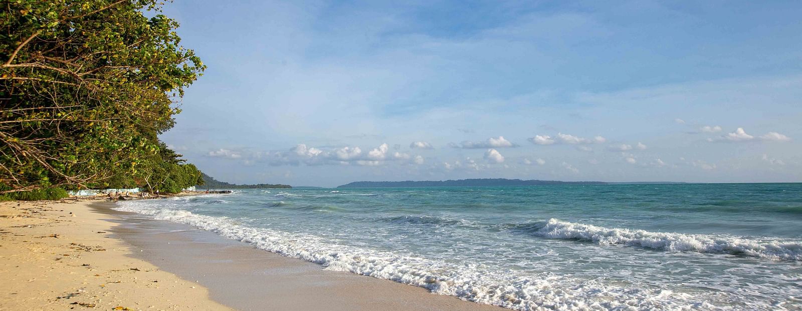 A stunning view of the beach with soft waves rolling onto the shore and a beautiful horizon. The bright sunlight and clear skies add to the peacefulness of the scene - Coral Reef Resort & Spa, Havelock