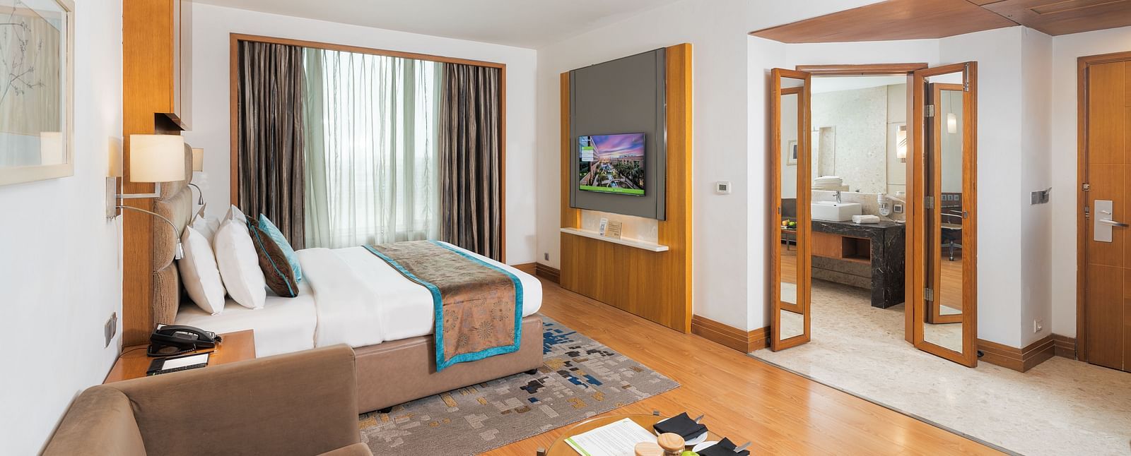 Elegantly furnished executive room featuring a comfortable seating area, work desk, and ample natural light - Nirvana Luxury Hotel, Ludhiana