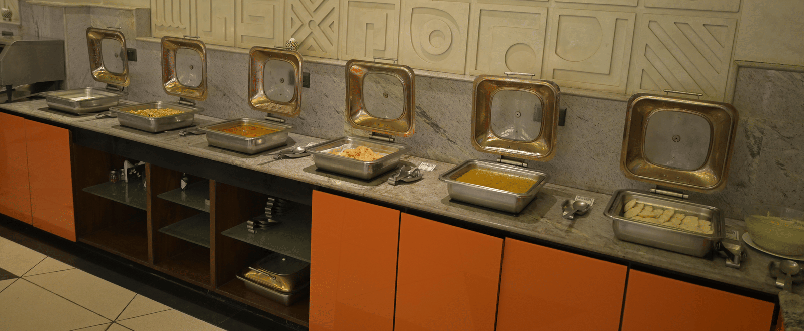 Long buffet line featuring chafing dishes and a tidy serving area at Hotel Sonar Bangla Mayapur.