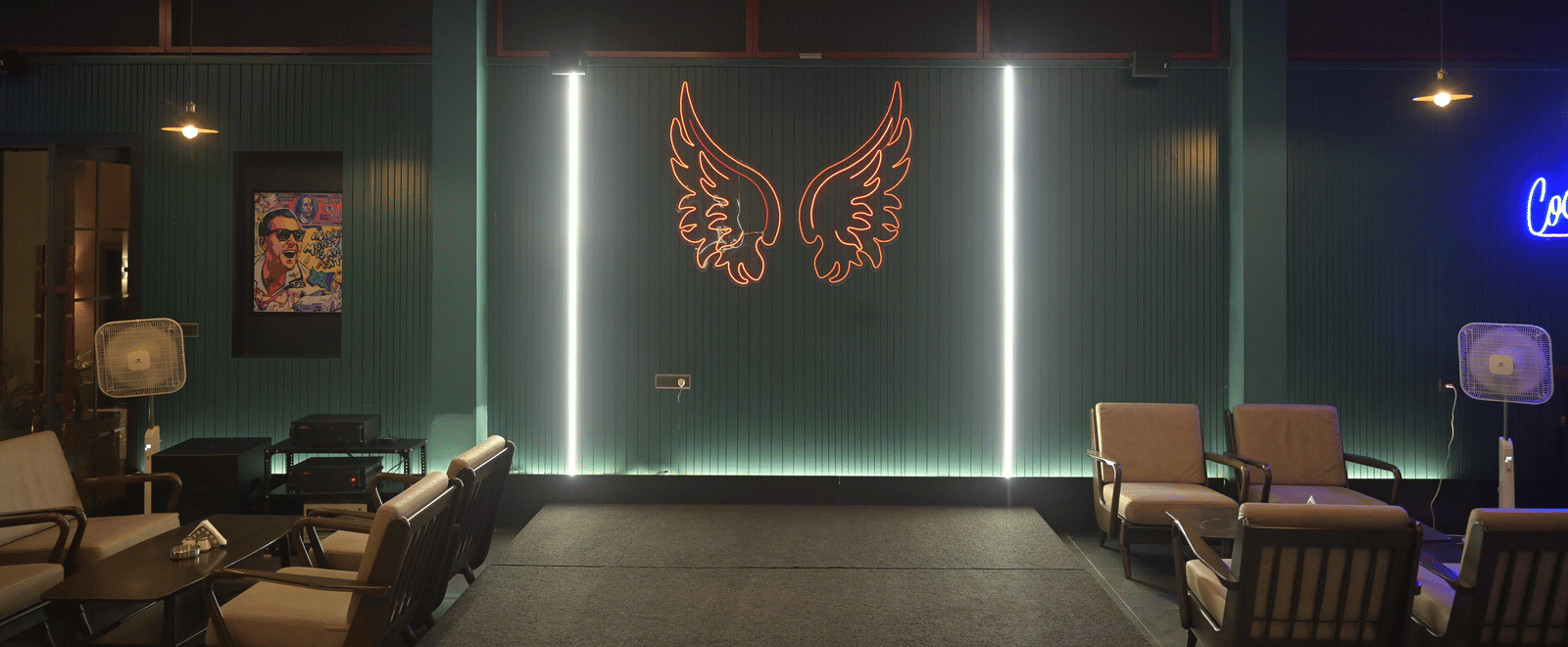 Front-facing view of the lounge bar with a lit butterfly artwork and comfortable seating arranged neatly at Hotel Sonar Bangla Mayapur.