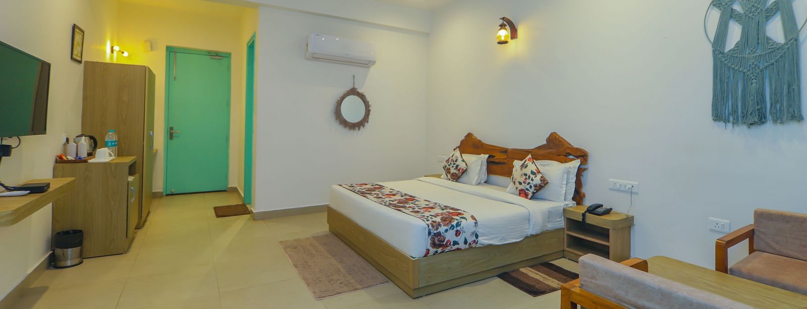 A spacious bedroom at Vedikant Resorts The Mallard Corbett features a bed, seating, and decor in a well-lit setting.