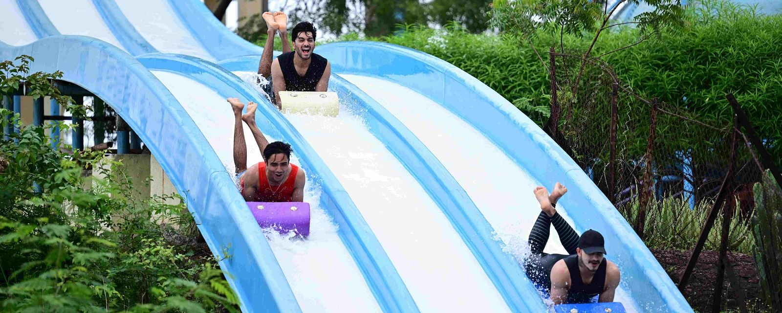 people sliding down a multi-lane water slide at an amusement park | Diamond Parks, Pune 