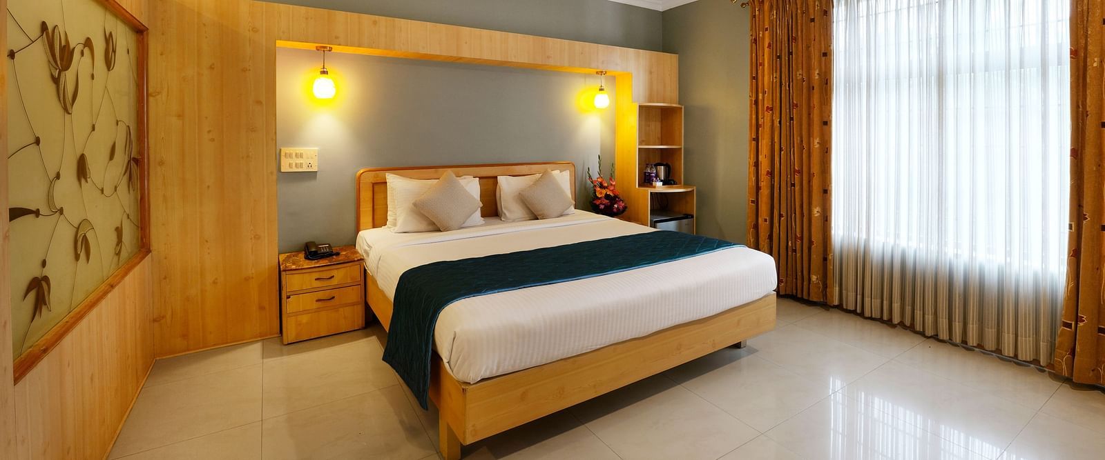 A spacious Suite with a king size bed and large windows - Cross Roads Inn, Bengaluru