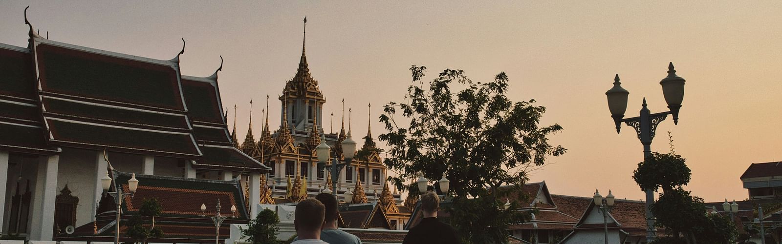 an overview of a temple in bangkok with people walking towards it.