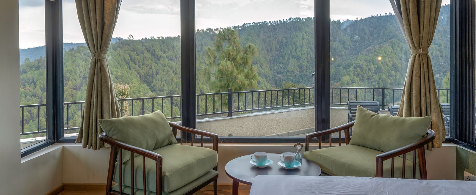 Spacious room with a seating area featuring armchairs and a view through large windows at The Chamomile Estate.