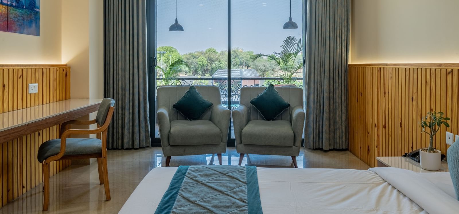 A spacious executive king room, with seating area and large window at Hotel Highway King, Bagru.