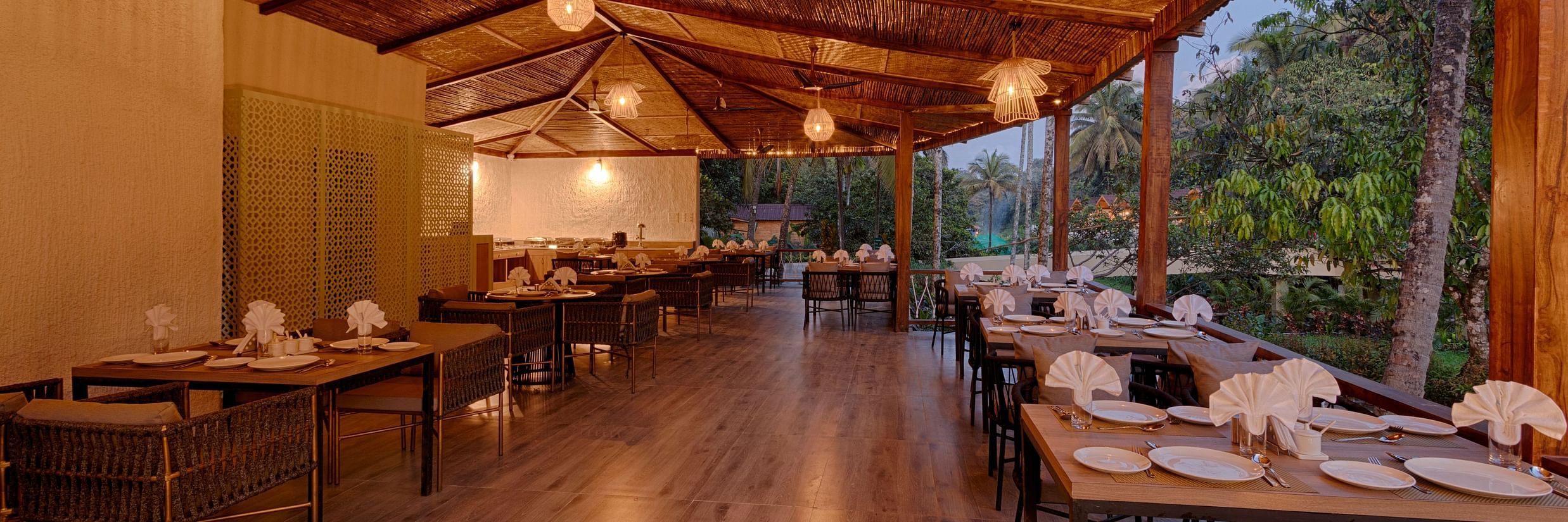 seating arrangements inside al fresco Dining with ceiling lights switched on - Stone Wood Jungle Resort, Dandeli