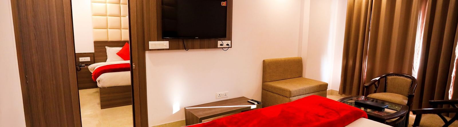 Image of a room with a bed and a door in front connecting to the next room in front at Amara Hill Queen, Mussoorie.