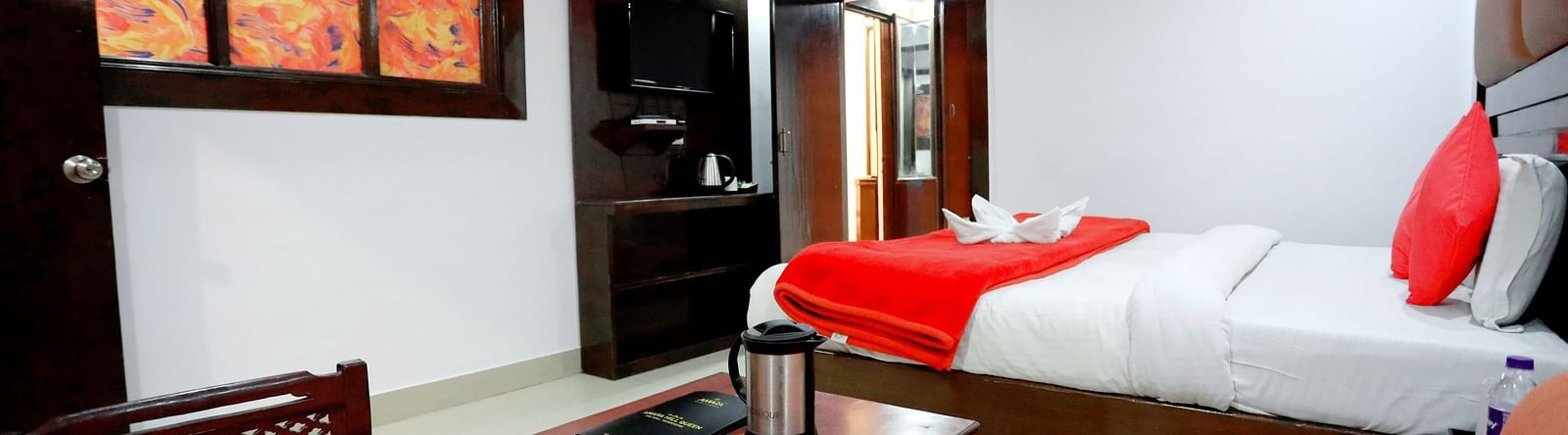 Side view of a room with a bed and a seating area with sofas on the side at Amara Hill Queen, Mussoorie.