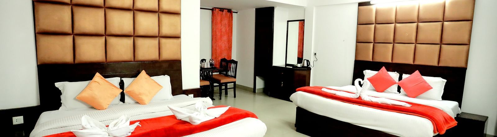 Image of a room with two beds and a table in front of the table at Amara Hill Queen, Mussoorie.