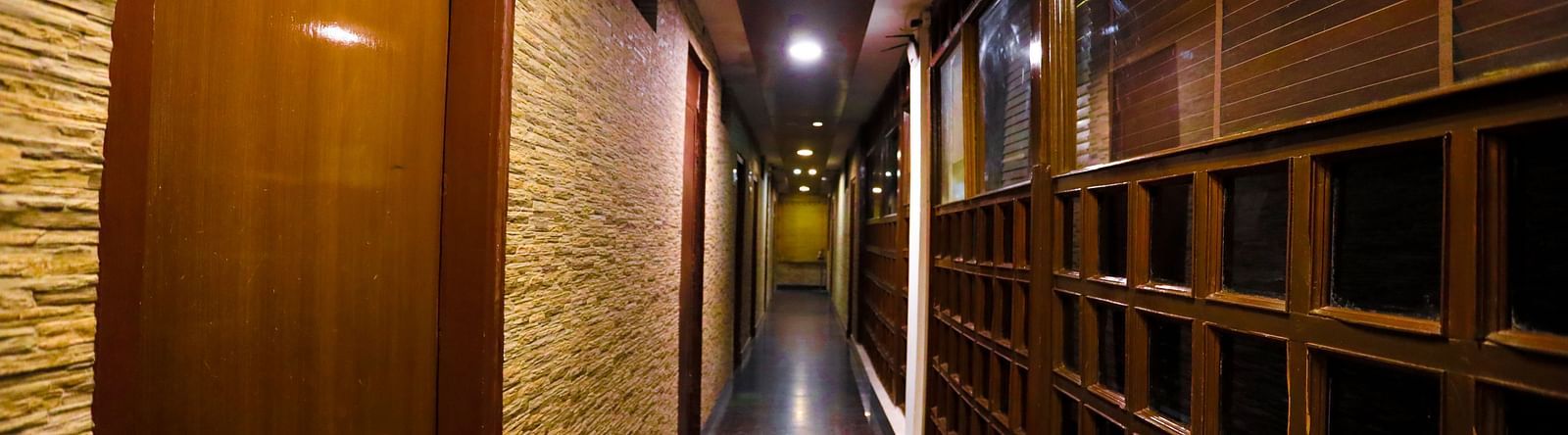 Image of a corridor with doors on the left at Amara Hill Queen, Mussoorie.