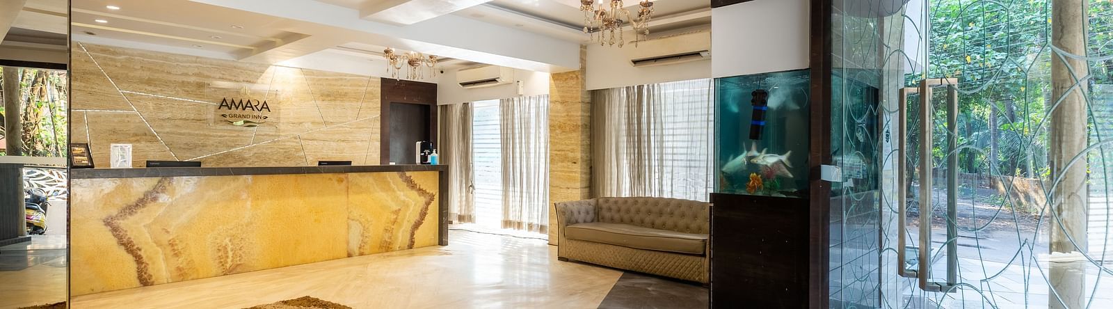 Image of a lobby area with a reception table and large glass doors at Calux Grand Inn, Calangute.