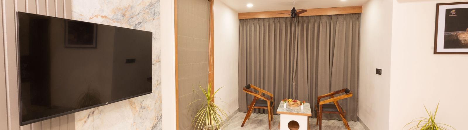 Wide view of the living area in the Daksh Bliss room at Daksh Eden Greenz.