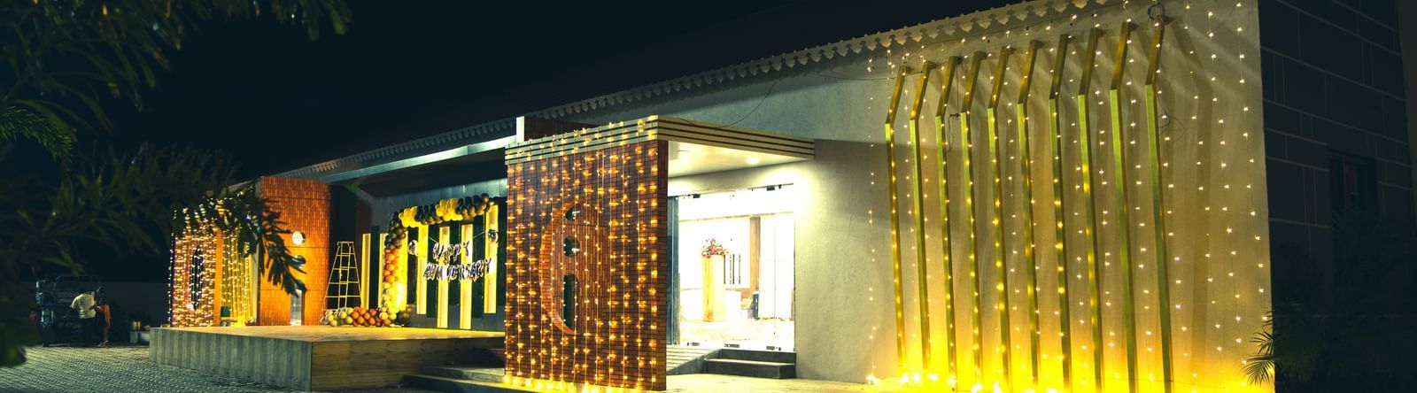 Night view of Daksh Hotels and Resorts with illuminated entrance and modern architecture.