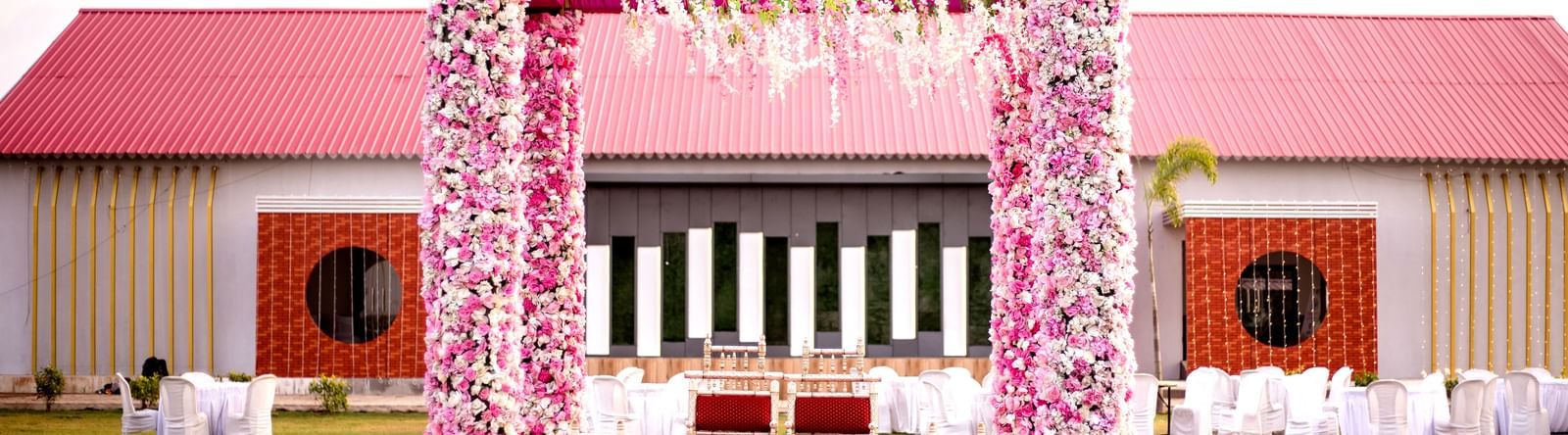 Lawn wedding mandap at Daksh Hotels and Resorts, adorned with pink flowers.