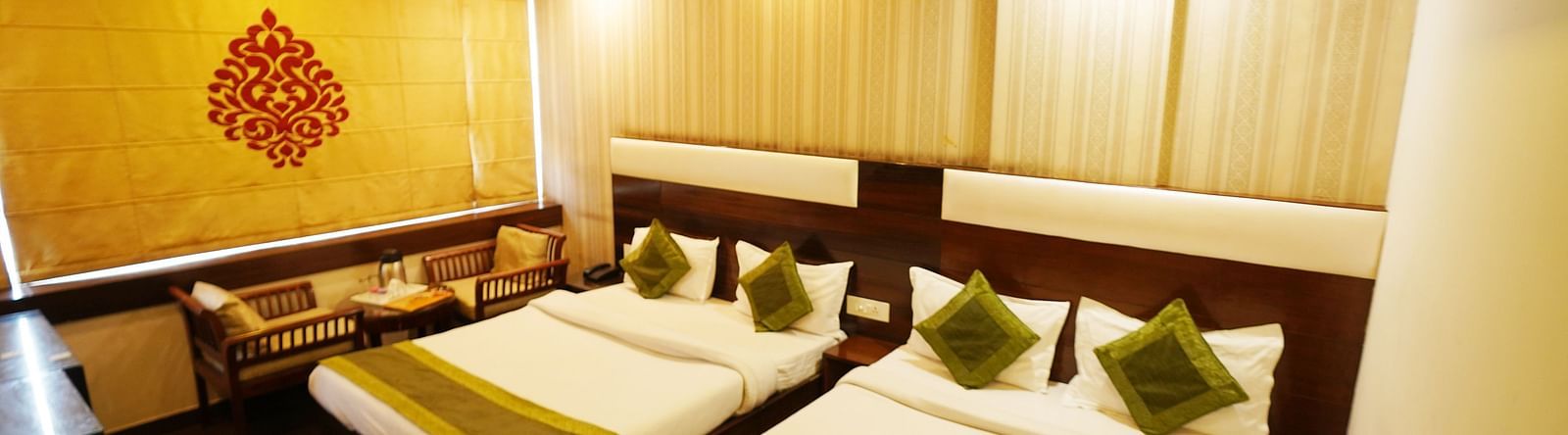 Family Room featuring two beds, a decorative wall design, and an air-conditioning unit.- Hotel Dreamland, Chandigarh