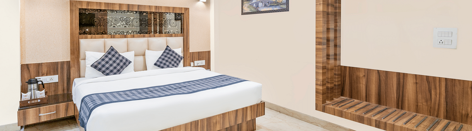 A corner view of the room at Hotel Moti Palace, focusing on the comfy bed.