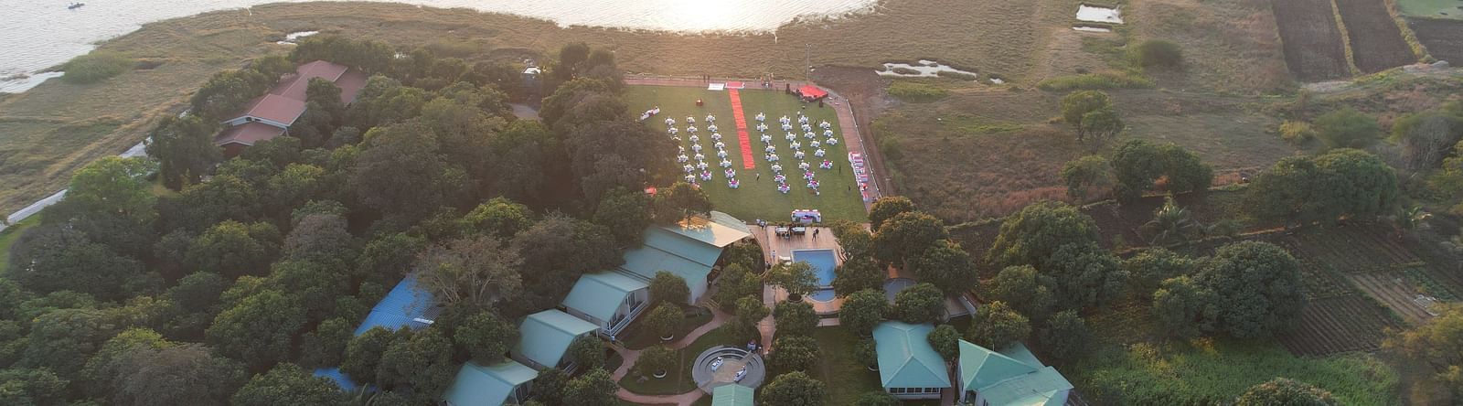 Panaromic view of the facade of Mango Leaf Lake Resort, Pune along with the lake in the backdrop